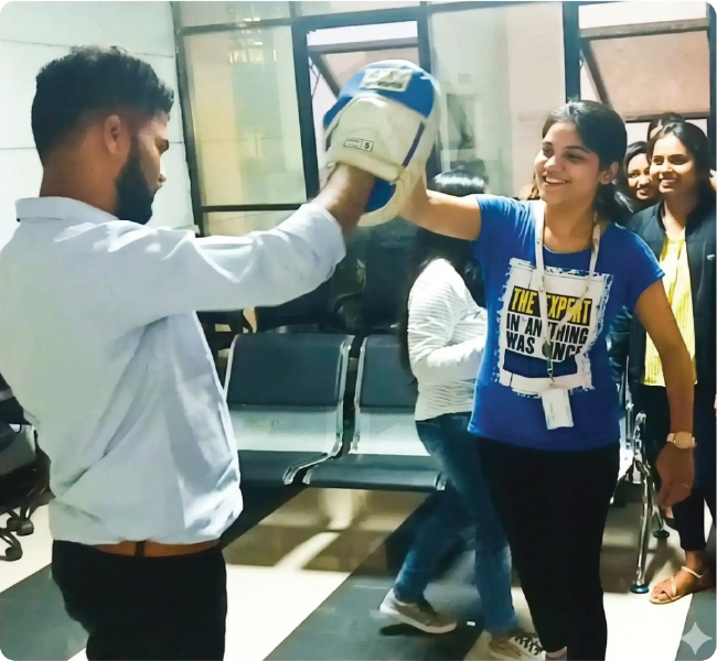 Woman practicing self-defence techniques with an instructor during a training session in a classroom setting